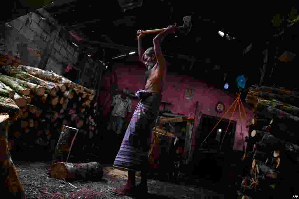 A worker cuts firewood at a workshop shop in Colombo, Sri Lanka.