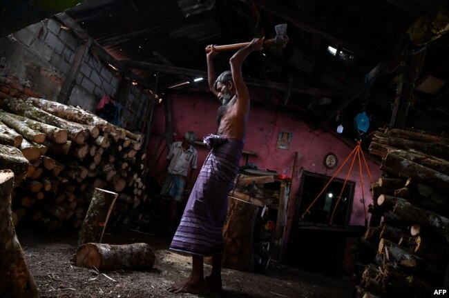 A worker cuts firewood at a workshop shop in Colombo, Sri Lanka. (Photo by Ishara S. KODIKARA / AFP)