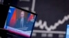 Russian President Vladimir Putin appears on a TV at the stock market in Frankfurt, Germany, Feb. 25, 2022, above the words, "Propaganda war online and on TV." Russia is accused of spreading disinformation aimed, in part, at influencing U.S. opinion to deny aid to Ukraine.