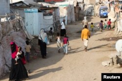 Orang-orang berjalan melalui kamp darurat untuk pengungsi internal (IDP) di Aden, Yaman 15 Maret 2022. (REUTERS/Fawaz Salman)