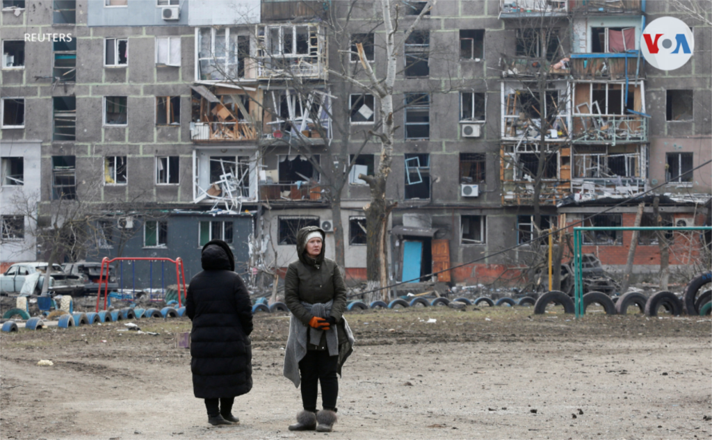 Ciudadanos observan uno de los edificios destruidos por los ataques. Según autoridades de la ciudad, más de 2.100 habitantes de Mariúpol han muerto desde la invasión rusa.