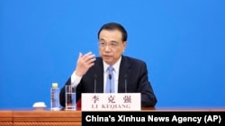 Chinese Premier Li Keqiang speaks during a press conference after the end of the closing session of China's National People's Congress (NPC) at the Great Hall of the People in Beijing, March 11, 2022. 