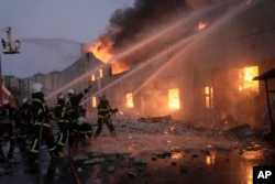 Ukrainian firefighters extinguish a blaze at a warehouse after a bombing in Kyiv, March 17, 2022.
