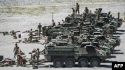 Американские войска у бронированных машин Stryker после участия в ежегодных совместных военных учениях США и Филиппин в Кроу-Вэлли в Капасе, провинция Тарлак, Филиппины, 10 апреля 2019 года