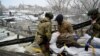 Ukrainian soldiers carry a wounded woman during the evacuation by civilians of the city of Irpin, northwest of Kyiv, March 8, 2022.