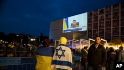 People gather in Habima Square in Tel Aviv, Israel, to watch Ukrainian President Volodymyr Zelenskyy in a video address to the Knesset, Israel's parliament, March 20, 2022. 