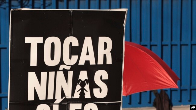 En esta foto del 4 de noviembre de 2019, una mujer sostiene una pancarta que dice: "tocar niñas si es un delito" durante una protesta en San Salvador, El Salvador.