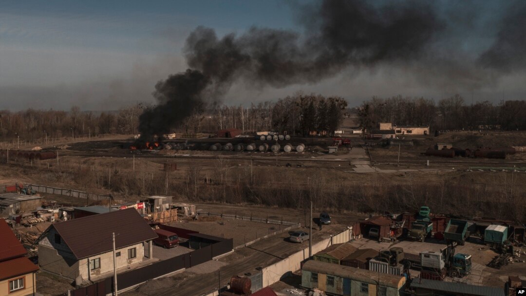 Asap mengepul dari kontainer yang terbakar setelah penembakan di Vasylkiv, barat daya Kyiv, Ukraina, Sabtu, 12 Maret 2022. (Foto: AP/Felipe Dana)