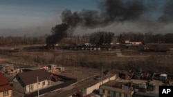 Asap mengepul dari kontainer yang terbakar setelah penembakan di Vasylkiv, barat daya Kyiv, Ukraina, Sabtu, 12 Maret 2022. (Foto: AP/Felipe Dana)