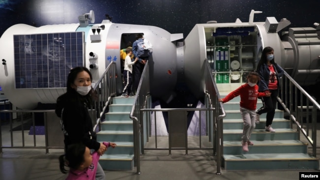 FILE - Visitors walk near an example space laboratory showing the development of China's space exploration, on the country's Space Day at the China Science and Technology Museum in Beijing, April 24, 2021. (REUTERS/Tingshu Wang)