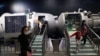 FILE - Visitors walk near a model of a space laboratory at an exhibition featuring the development of China's space exploration, on the country's Space Day at the China Science and Technology Museum in Beijing, April 24, 2021.