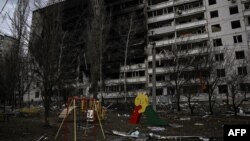 乌克兰哈尔科夫被严重炸毁的住宅楼和楼前的儿童游乐园。（2022年3月27日）