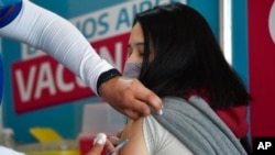 ARCHIVO- Un trabajador de la salud vacuna a una joven contra el COVID-19 con una dosis donada por Estados Unidos en Quilmes, Argentina, el 3 de agosto de 2021. 