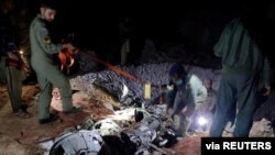 People inspect what Pakistani security sources say are the remains of a missile fired into Pakistan from India, near Mian Channu, Pakistan, March 9, 2022. (Pakistani security sources/Handout via Reuters)