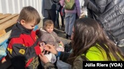 Natalia reparte golosinas a unos niños recién llegados al refugio temporal de Korczowa.