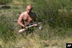 FILE -- In this Sept. 2010 file photo released Oct. 30, 2010, Russian President Vladimir Putin (then the prime minister) carries a hunting rifle in Russia's Siberian Tyva region.