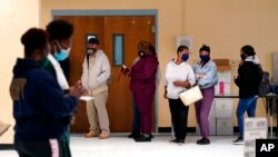 FILE - People line up to vote on Election Day at Martin Luther King Jr. Elementary School, in the Lower Ninth Ward of New Orleans, Nov. 3, 2020.