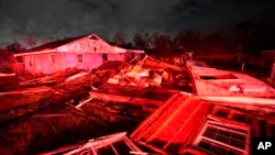 Destroyed homes, illuminated by fire engine lights, are seen after a tornado struck the area in Arabi, La., Tuesday, March 22, 2022. 
