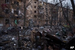 一名警察走过基辅被俄军炸坏的居民楼。(2022年3月18日)