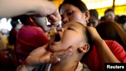 FILE - A child receives a polio vaccine during a government-led vaccination program in Quezon City, Philippines, Oct. 14, 2019. The UK Health Security Agency is urging parents to make sure their children are vaccinated after polio was detected in sewage samples in London in 2022.