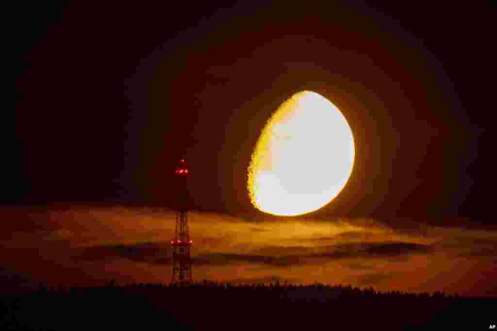 The moon sets behind the hills of the Taunus region near Frankfurt, Germany.