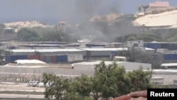 FILE - Smoke rises from behind buildings, in Mogadishu, Somalia, March 23, 2022, in this still image obtained from a social media video. (Twitter/@Hajishire/via Reuters)