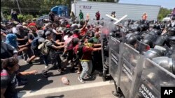 Migrantes rompen un retén de la Guardia Nacional que intenta impedirles salir de Tapachula, México, el 1 de abril de 2022.