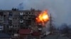 An explosion is seen in an apartment building after a Russian army tank fires in Mariupol, Ukraine, March 11, 2022.