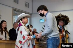 FILE - Canada's Prime Minister Justin Trudeau shakes hands with Joan Gentles of Chilcotin First Nation (Tsilhqot'in) during a welcome ceremony at the Williams Lake First Nation, near the former St. Joseph's Mission Residential School, where an initial sweep had