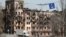 Người dân địa phương đi ngang qua một toà nhà bị tấn công ở thành phố cảng Mariupol, Ukraine, vào ngày 3/4/2022