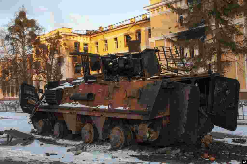Un vehículo blindado destruido frente a un edificio dañado por los bombardeos en Kharkiv, Ucrania, el viernes 11 de marzo de 2022. (Foto AP/Andrew Marienko)