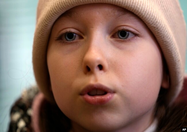 Annamaria Moslovska, a ten-year-old from Kharkiv, eastern Ukraine, speaks in a waiting room at the train station in Zahony, Hungary, Monday, March 7, 2022. (AP Photo/Darko Vojinovic)