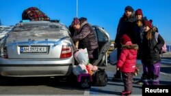 Displaced people stand next to a car after fleeing Mariupol amid Russia's ongoing attacks on Ukraine, in Zaporizhzhia, Ukraine, March 19, 2022. 