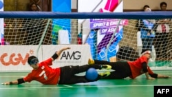 Atlet asal Jepan Kaneko Kazuya (kanan) dan Taguchi Yuji (kiri) berusaha mengamankan gawang mereka dalam pertandingan goalball melawan Korea Selatan pada ajang Asian Para Games 2018 di Jakarta, pada 12 Oktober 2018. (Foto: AFP/Bay Ismoyo)