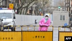 Seorang petugas mengenakan baju hazmat ketika berjaga di area Distrik Huangpu di Shanghai, China, yang tengah menjalani lockdown pada 21 Maret 2022. (Foto: AFP/Hector Retamal)
