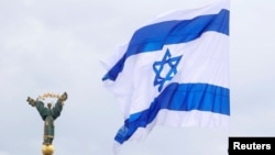 Ilustrasi - Bendera Israel berkibar di dekat Monumen Kemerdekaan dalam aksi aktivis pro-Israel di Kyiv, Ukraina, 14 Mei 2021. (REUTERS/Valentyn Ogirenko)