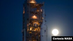 Imagen de la Luna saliendo detrás del cohete del Sistema de Lanzamiento Espacial (SLS) de la NASA con la nave espacial Orion a bordo de un lanzador móvil mientras se desplaza hacia el Complejo de Lanzamiento 39B por primera vez, el 17 de marzo de 2022.