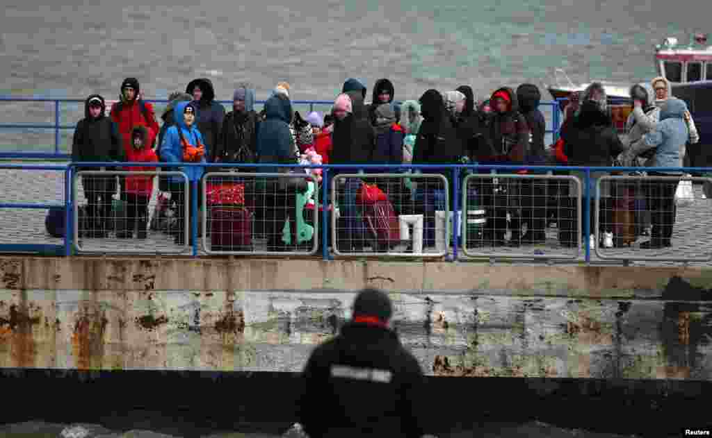 People arrive by ferry, after fleeing from Russia&#39;s invasion of Ukraine, at the Isaccea-Orlivka border crossing, Romania, March 10, 2022.