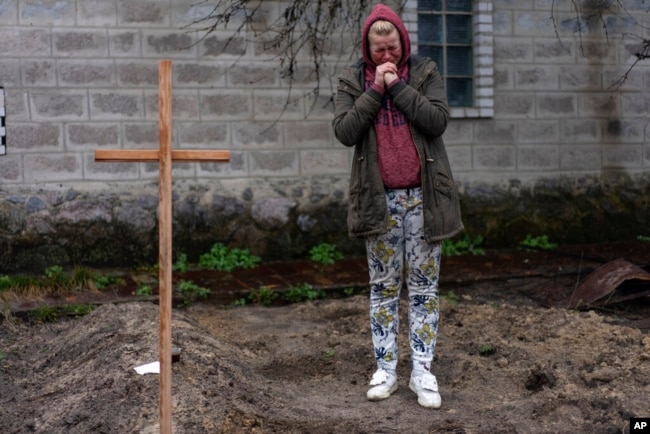 Mariya Ol'hovs'ka, 33 tuổi, khóc thương cha cô Valerii Ol'hovs'kyi, 72 tuổi, chết khi phi đạn của Nga bắn vào gần nhà họ vào ngày 30 tháng 3, ở ngoại ô Kyiv, Ukraine, ngày 1 tháng 4 năm 2022