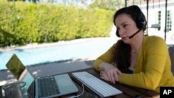 Julia Entin sentada frente a su computadora en la oficina de su patio trasero, coordinando los esfuerzos para rescatar a los sobrevivientes del Holocausto en Ucrania, el lunes 14 de marzo de 2022, en Los Ángeles. (Foto AP/Richard Vogel)