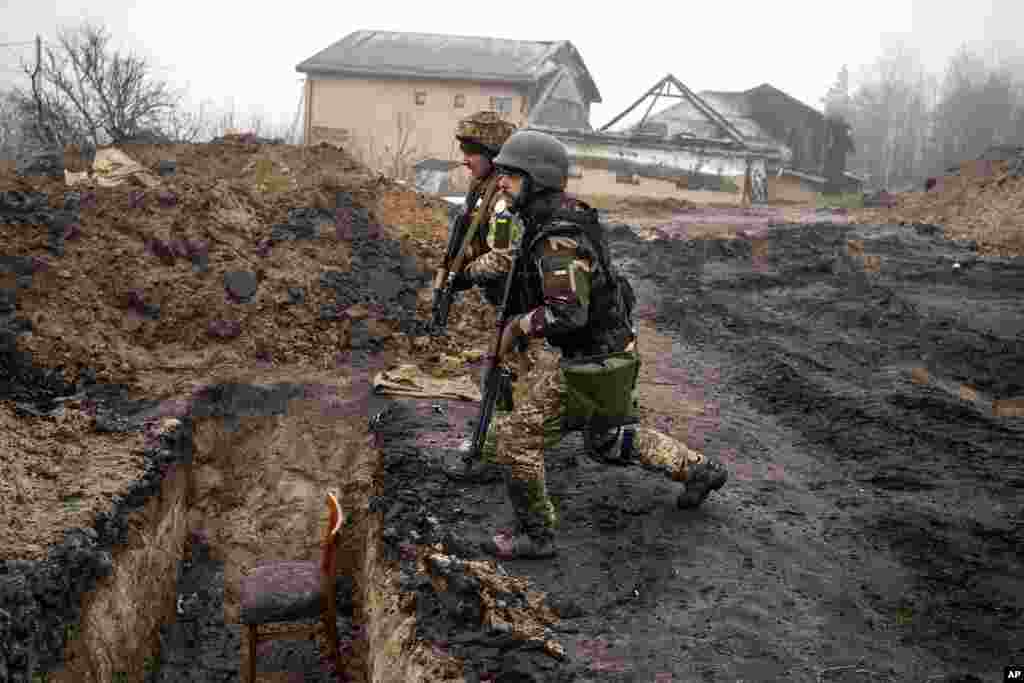 Ukrainian soldiers inspect trenches used by Russian soldiers during the occupation of villages on the outskirts of Kyiv, Ukraine.