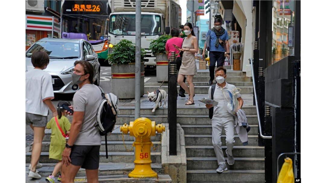 Warga mengenakan masker saat beraktifitas di Hong Kong, 15 Maret 2022. (AP/Kin Cheung)