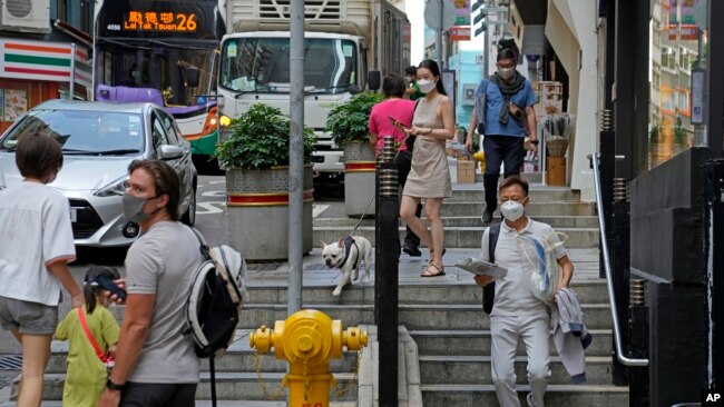 Las personas que usan máscaras faciales caminan solas por una calle en Hong Kong, el 15 de marzo de 2022.