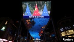 Una pantalla gigante muestra imágenes de noticias de banderas nacionales chinas y banderas de la Unión Europea durante una cumbre virtual UE-China, en Beijing, China, el 1 de abril de 2022.