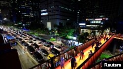 Sejumlah warga Jakarta menyeberang melalui jembatan penyeberangan pada jam sibuk di sore hari di kawasan bisnis di Jakarta, 15 Maret 2022. (Foto: REUTERS/Willy Kurniawan)