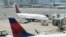 ARCHIVO - Los aviones de pasajeros de Delta Air Lines descansan en la pista, el 21 de julio de 2021, en el Aeropuerto Internacional Logan de Boston, en Boston.