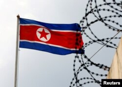 Bendera Korea Utara berkibar di samping kawat berduri di Kedutaan Korea Utara di Kuala Lumpur, Malaysia, 9 Maret 2017. (Foto: REUTERS/Edgar Su)