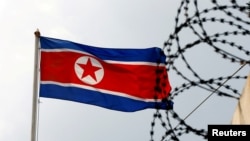 资料照：朝鲜国旗与高墙上的铁丝网 