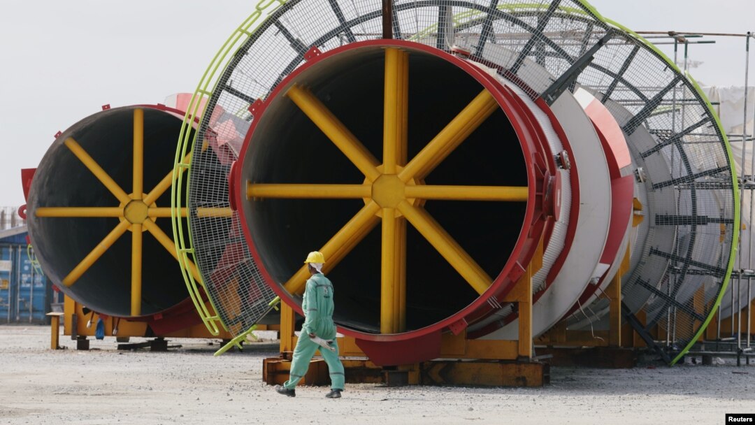 FILE - A worker walks past structural parts of an under-construction oil refinery plant at Dangote refinery in Ibeju Lekki district, on the outskirts of Lagos, Nigeria, Aug. 7, 2019.
