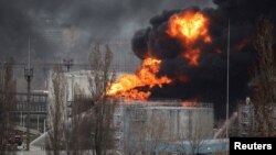 Petugas sedang berupaya memadamkan kebakaran di kilang minyak akibat serangan rudal di dekat kota pelabuhan Odesa, di tengah invasi Rusia yang sedang berlangsung, di Ukraina, 3 April 2022. (Foto: REUTERS/Nacho Doce)